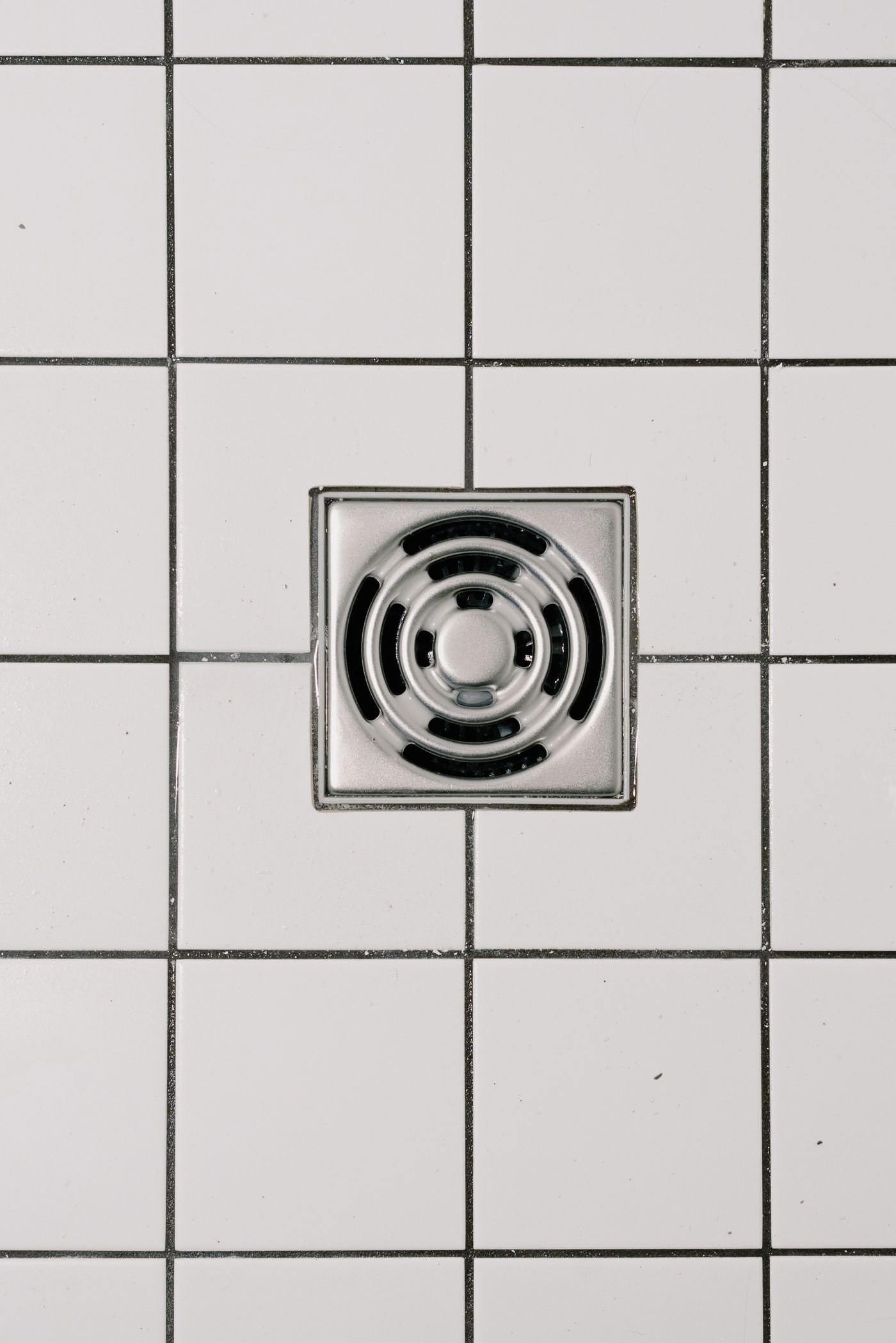 Bonde de douche dans un carrelage blanc
